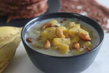 Ripe plantain stew. A sweet curry made of ripe plantain, coconut milk and seasoned with roasted cashews. Served with red rice pancakes