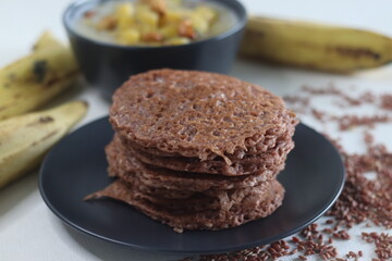Red rice pancakes. Pancakes made of a fermented batter of red rice and coconut. Served with Ripe plantain stew