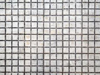 Grunge background. Dirty white small square tiles. Close-up of an urban pavement - obrazy, fototapety, plakaty