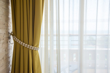 Beautiful yellow curtain shell decoration in resort interior with daylight.