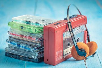 Retro audio cassette with orange headphones and player.