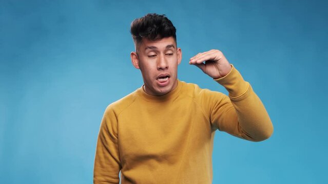 Man showing bla bla gesture while standing against an isolated background.