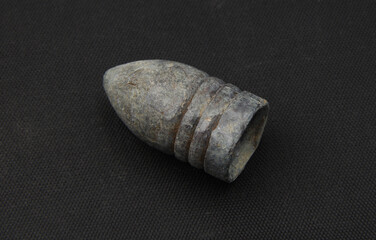 Old lead bullet on black background