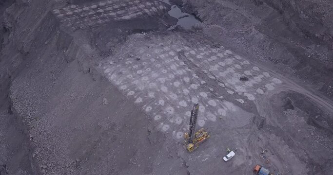 Aerial view of blasting holes coal mining area, open-pit mine, quarrying.  Drone shooting preparing for blasting open cast mine mining of coal, overall plan.