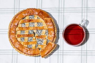 Homemade cake with cottage cheese and poppy seeds on a checkered tablecloth. Top view