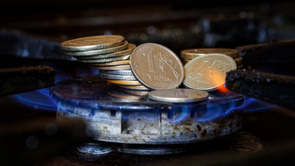 Stack of coins - Russian rubles lies in the middle of a lit gas burner. The concept of gas prices....