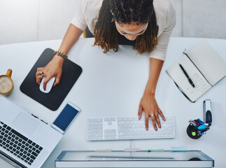 Fully focused. No distractions. High angle shot of a young businesswoman working at her desk in the...