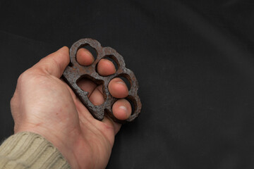 rusty German brass knuckles on a black background