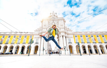 Happy man enjoying freedom jumping outside on city street - Delightful tourist in Commerce Square...