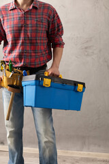 Worker man holding construction tool box in house room renovation. Male hand and toolbox - 495090823