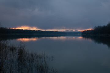 Obraz na płótnie Canvas Landscape of River Sava and Motajica mountain with dark clouds at dusk