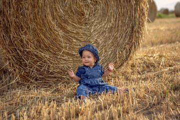 Naklejka na ściany i meble Baby girl at the wheat field