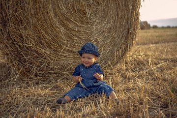 Naklejka na ściany i meble Happy Baby girl at the wheat field