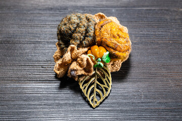 handcrafted brooch with felt rose flowers close up on dark wooden board
