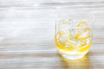single malt scotch whisky on the rocks on gray wooden table with copyspace