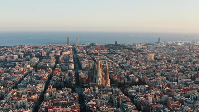 Aerial wide shot city panorama of Barcelona with modern and traditional architecture of urban landscape. Sagrada Familia church is in centre. Torre Mapfre and Hotel Arts are on background close to sea