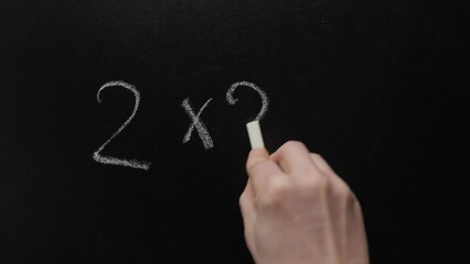 Two and two make four. Hand writing chalk blackboard school simple math addition two multiply two equals four. Inscription 2x2=4 simple mathematical equation board writing chalkboard education concept - Powered by Adobe