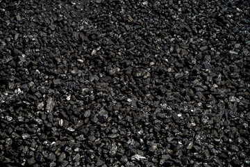 full frame close-up of Heap of black coal stored at a narrow gauge train station that still operates steam engines 