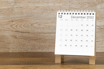 December 2022 desk calendar on wooden background.