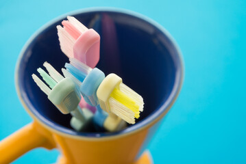 Close up colorful toothbrush in ceramic cup - dental care concept.