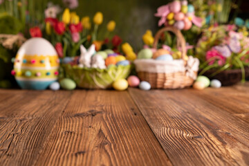 Obraz na płótnie Canvas Easter time. Easter decorations on the rustic wooden table. Easter bunny, easter eggs in basket and cabbage leaf. Bouquets of spring flowers. 