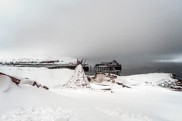 Wooden structures covered with the snow standing by the sea