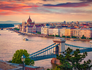Naklejka na ściany i meble Exciting evening view of Parliament house and Szechenyi Chain Bridge. Superb spring sunset in Budapest, Hungary, Europe. Traveling concept background.