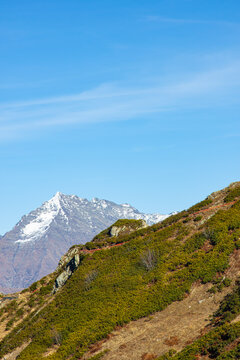 Beautiful landscape in the mountains with peaks against the blue sky and valleys covered with grass