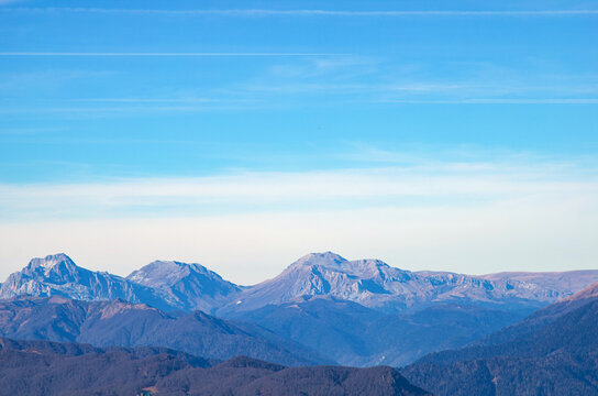 Beautiful landscape in the mountains with peaks against the blue sky and valleys covered with grass
