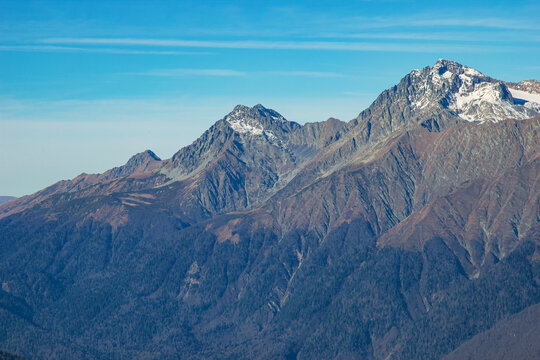 Beautiful landscape in the mountains with peaks against the blue sky and valleys covered with grass