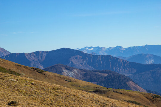 Beautiful landscape in the mountains with peaks against the blue sky and valleys covered with grass