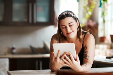Theres a lot we can relate to on social media. Shot of a young woman using a digital tablet in the...