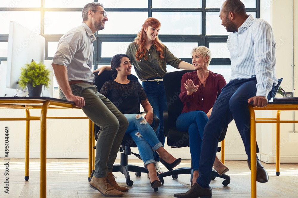Poster determined to succeed together. shot of a group of designers having a discussion in an office.