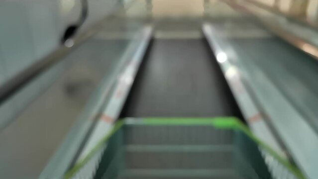 Footage 1080p. Blurred image, shopping cart on escalator, going down.