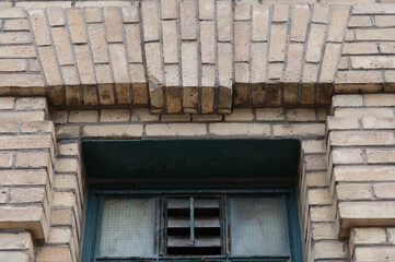 Fototapeta na wymiar old brick building with exhaust fan and window
