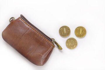 Ten-ruble coins by a leathern purse. Russian ruble coins on white background. Russian metal money....