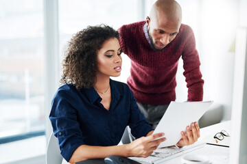 I was just reading over this paperwork.... Cropped shot of a male supervisor helping an attractive...