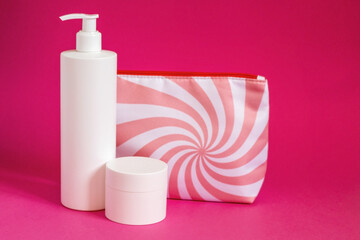 Obraz na płótnie Canvas Various cosmetic products with cosmetic bag. Beauty care accessories, cream and shampoo or lotion cosmetic set on pink background