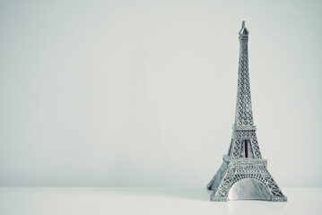 Eiffel tower model on white wall background copy space. Travel in Europe concept.