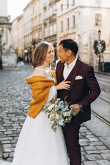 An international wedding couple, a European bride and an Asian groom walk around the city together.