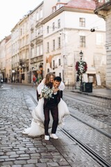 An international wedding couple, a European bride and an Asian groom walk around the city together.