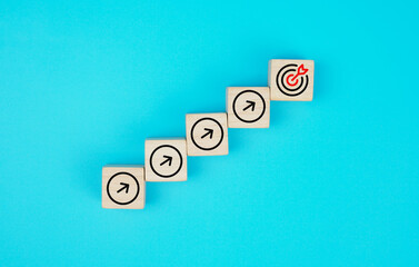 The process of successfully growing a business idea. Stacked wooden blocks on a blue paper...