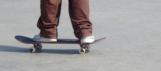 Pieds sur skateboard sur une place urbaine prévue pour les sports de glisse