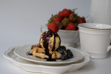 Waffle with Ice cream and Chocolate syrup topped with red strawberry