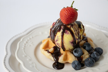 Waffle with Ice cream and Chocolate syrup topped with red strawberry