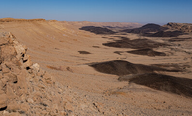 Obraz na płótnie Canvas View of Ramon Crater with remanats of ancient volcanoes as seen from its most Western end as seen from Mount Ramon, located in the Negev Desert, south of Beer Sheba, Southern Israel, Israel. 