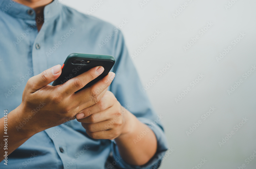Aufkleber close up of a man using mobile smart phone searching internet, sending sms, using text messenger or 