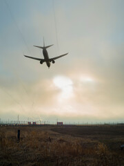 Fototapeta na wymiar the passenger plane landing at the airport at sunset