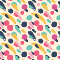 Seamless background with bright polka dots. Drawn by hand with a dry brush and colored ink.