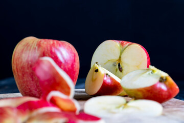 cutting old board with pieces of red ripe apple